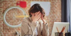 Mujer con dolor de cabeza en el trabajo. Millann (iStock)